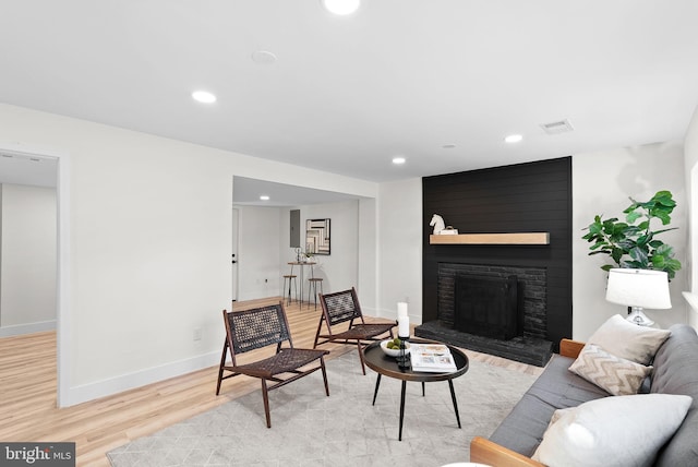 living room featuring light wood-type flooring and a fireplace