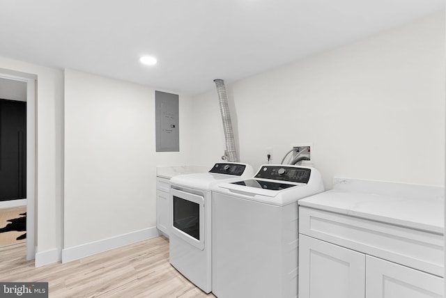 laundry room featuring cabinets, electric panel, independent washer and dryer, and light wood-type flooring