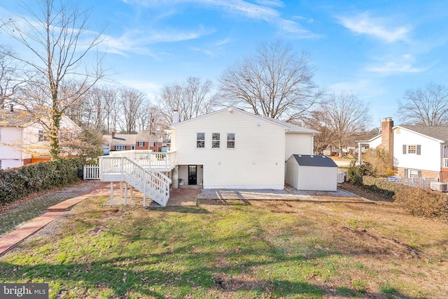 back of house featuring a shed, a wooden deck, and a yard