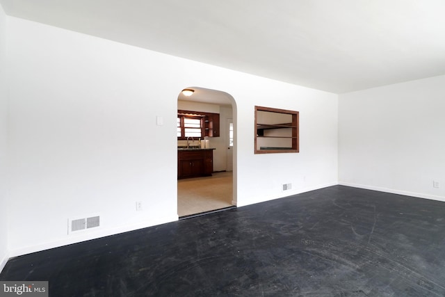 unfurnished room featuring sink and concrete floors