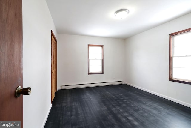 unfurnished room with a baseboard radiator and dark wood-type flooring