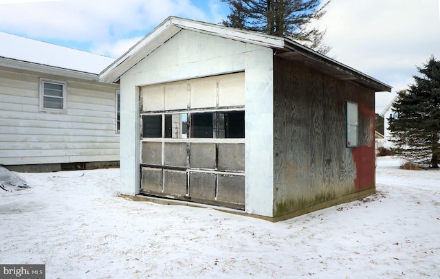 snow covered structure with a garage