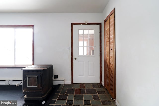 doorway featuring a baseboard heating unit and a wood stove