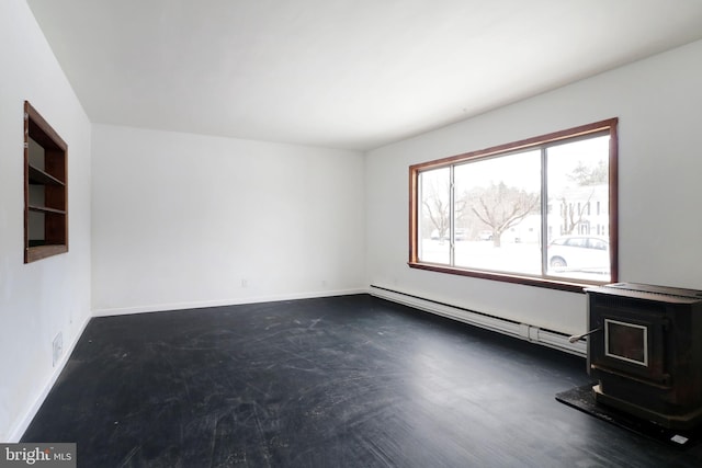 unfurnished room with baseboard heating and a wood stove