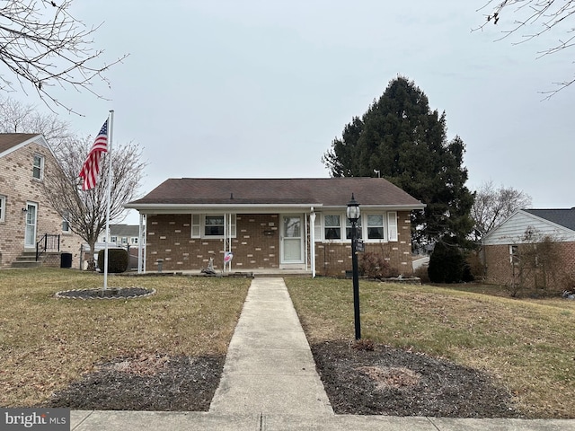 view of front of house with brick siding and a front yard