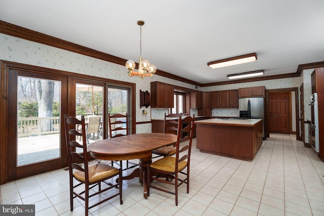 dining space with light tile patterned floors, a chandelier, crown molding, and wallpapered walls