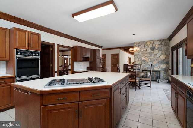 kitchen featuring black oven, crown molding, light countertops, and gas stovetop