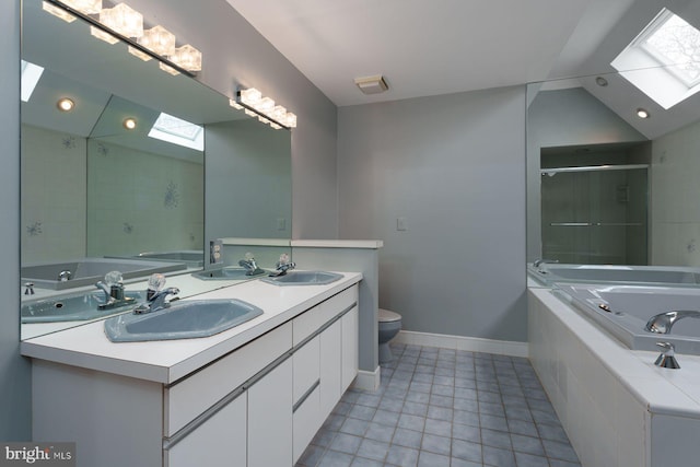 full bathroom featuring vaulted ceiling with skylight, a garden tub, and a sink