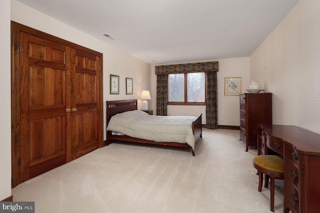 bedroom with light carpet, visible vents, and baseboards