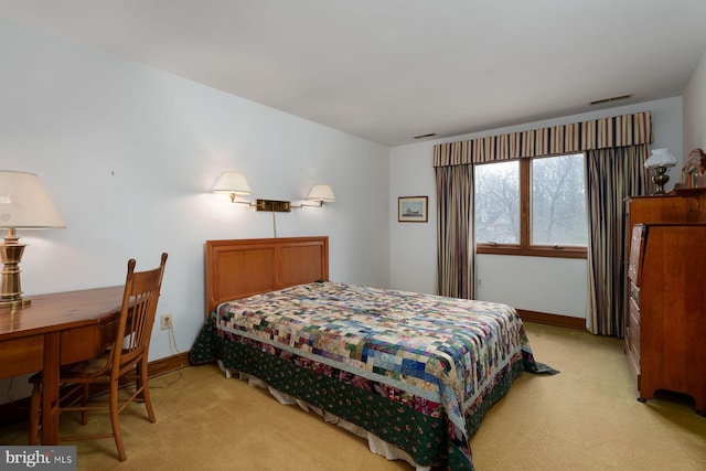 bedroom featuring visible vents, baseboards, and light carpet