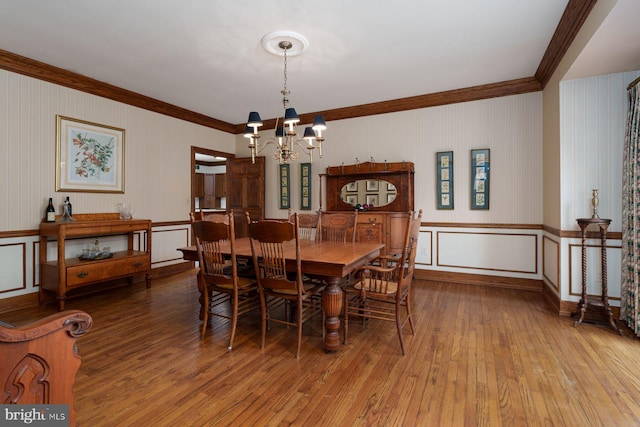 dining room featuring an inviting chandelier, crown molding, and wood-type flooring