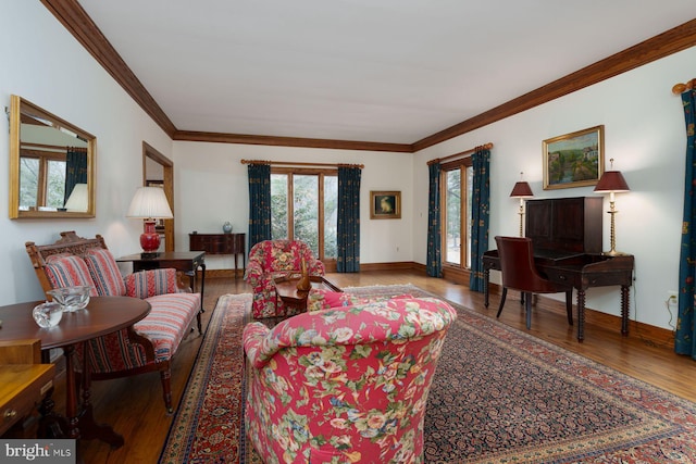 living room featuring crown molding, baseboards, and wood finished floors