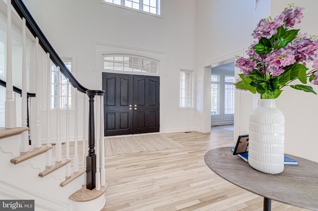 entrance foyer with stairway, plenty of natural light, and light wood-style flooring