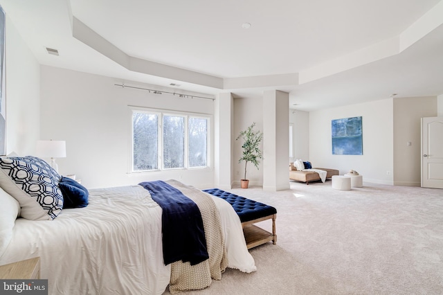 carpeted bedroom featuring a raised ceiling, visible vents, and baseboards