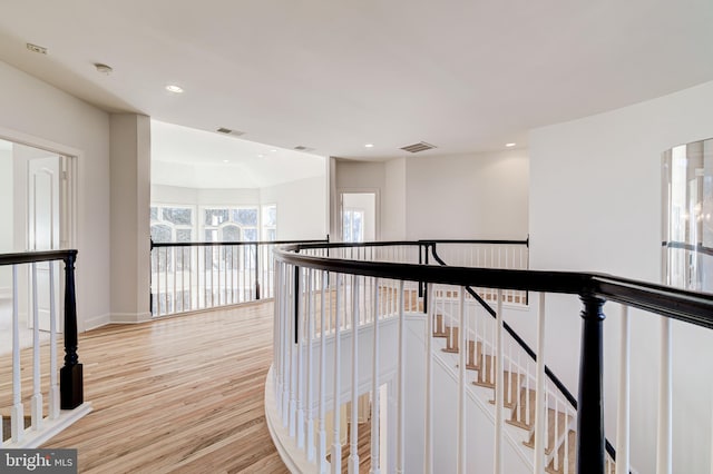 hallway featuring recessed lighting, an upstairs landing, visible vents, and light wood-style floors