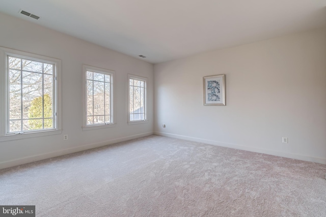 unfurnished room with light carpet, baseboards, and visible vents