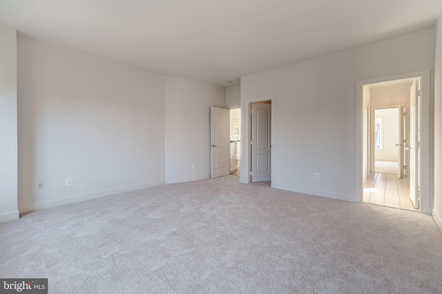 unfurnished bedroom with light colored carpet and baseboards