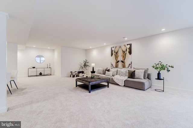 living area featuring baseboards, recessed lighting, and light colored carpet