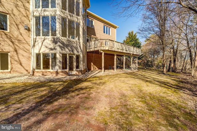 back of house featuring a lawn and a wooden deck