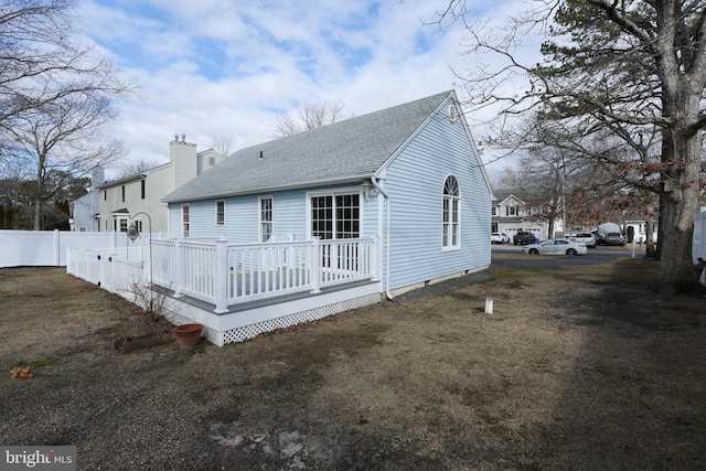 rear view of house with a lawn and a deck