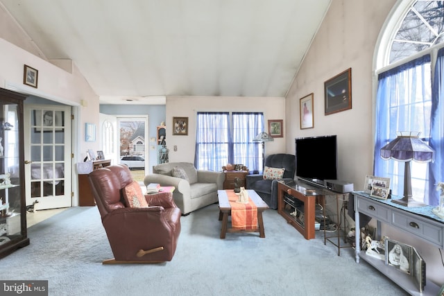 living room with high vaulted ceiling and carpet flooring