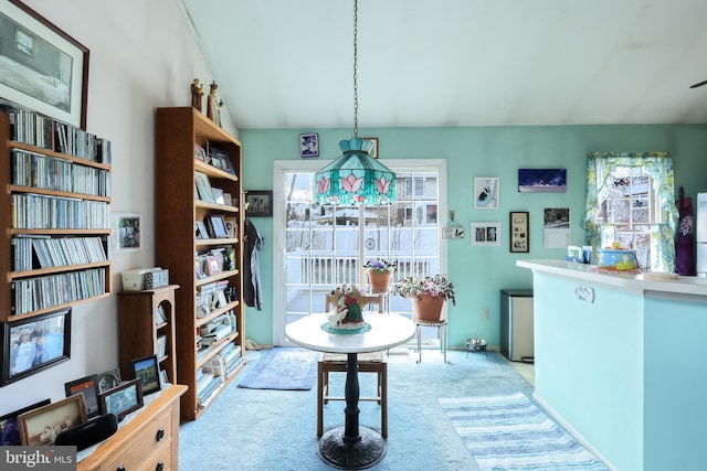 dining space with lofted ceiling and light colored carpet