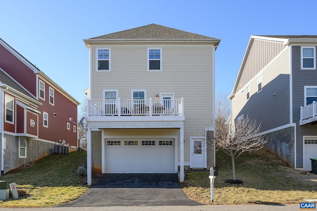 view of front property with a garage, central air condition unit, and a balcony