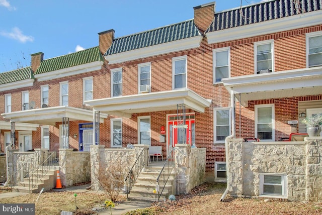 multi unit property with brick siding and a tiled roof