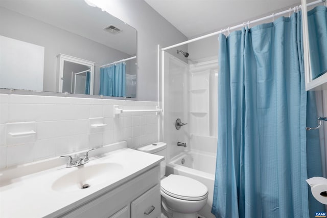 full bathroom with shower / tub combo with curtain, vanity, toilet, and tile walls