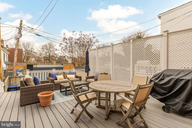 wooden deck with outdoor dining space, a jacuzzi, fence, and an outdoor living space