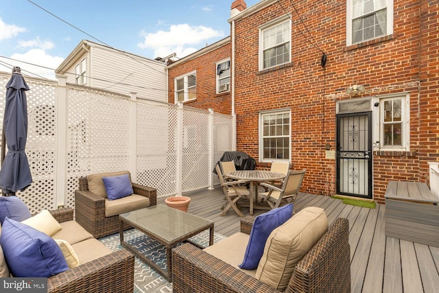 wooden terrace with fence and an outdoor hangout area