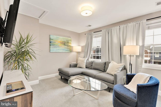 living area featuring attic access, light carpet, visible vents, and baseboards