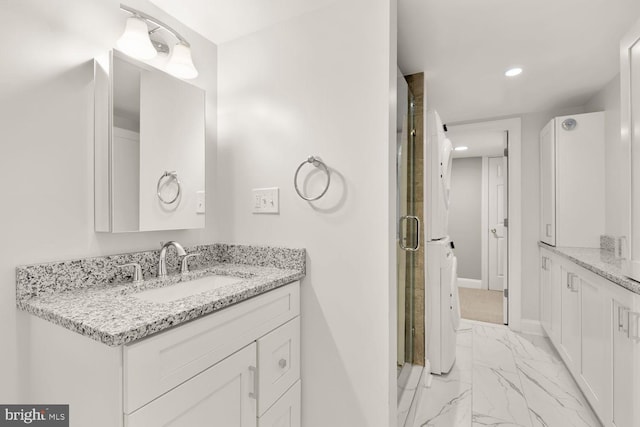 bathroom with a stall shower, baseboards, marble finish floor, and vanity