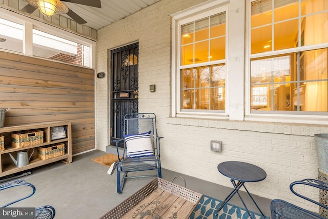 exterior space with a ceiling fan and brick siding