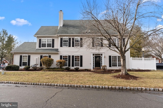 colonial house featuring a front lawn