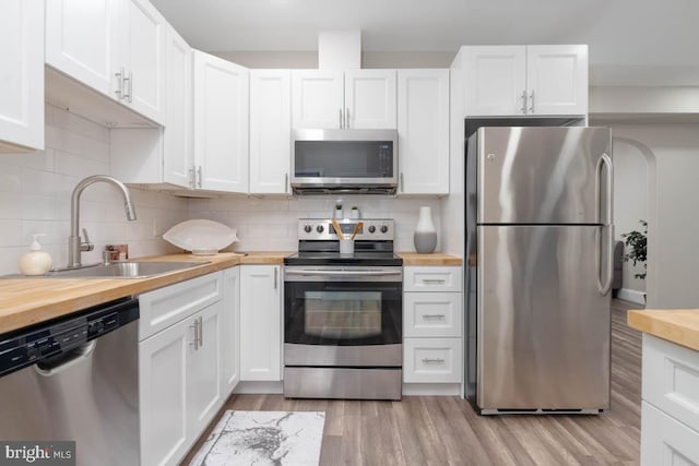 kitchen with white cabinetry, sink, wooden counters, and appliances with stainless steel finishes