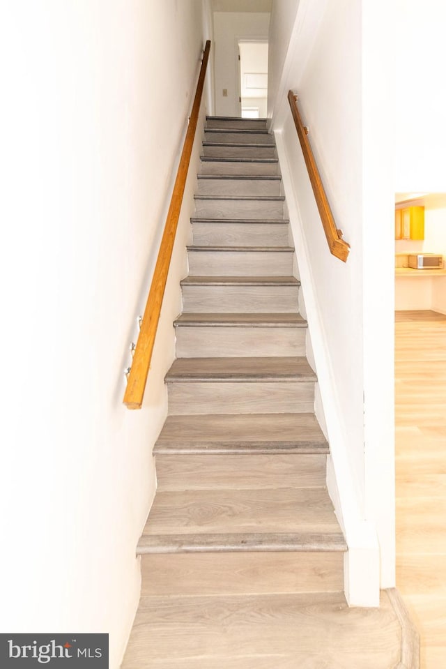 stairs featuring hardwood / wood-style flooring