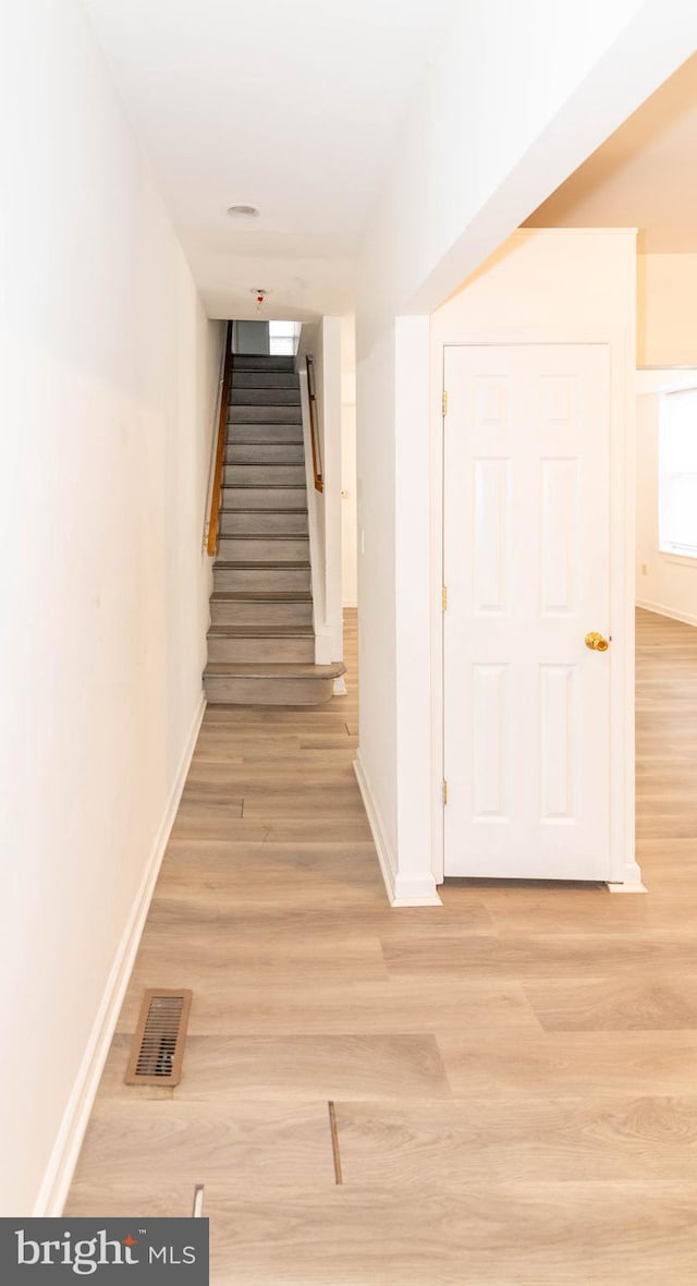 hallway with light hardwood / wood-style floors