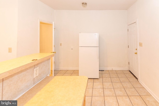 kitchen with white fridge and light tile patterned floors