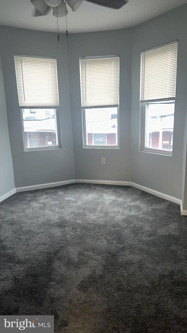 carpeted empty room featuring ceiling fan and plenty of natural light