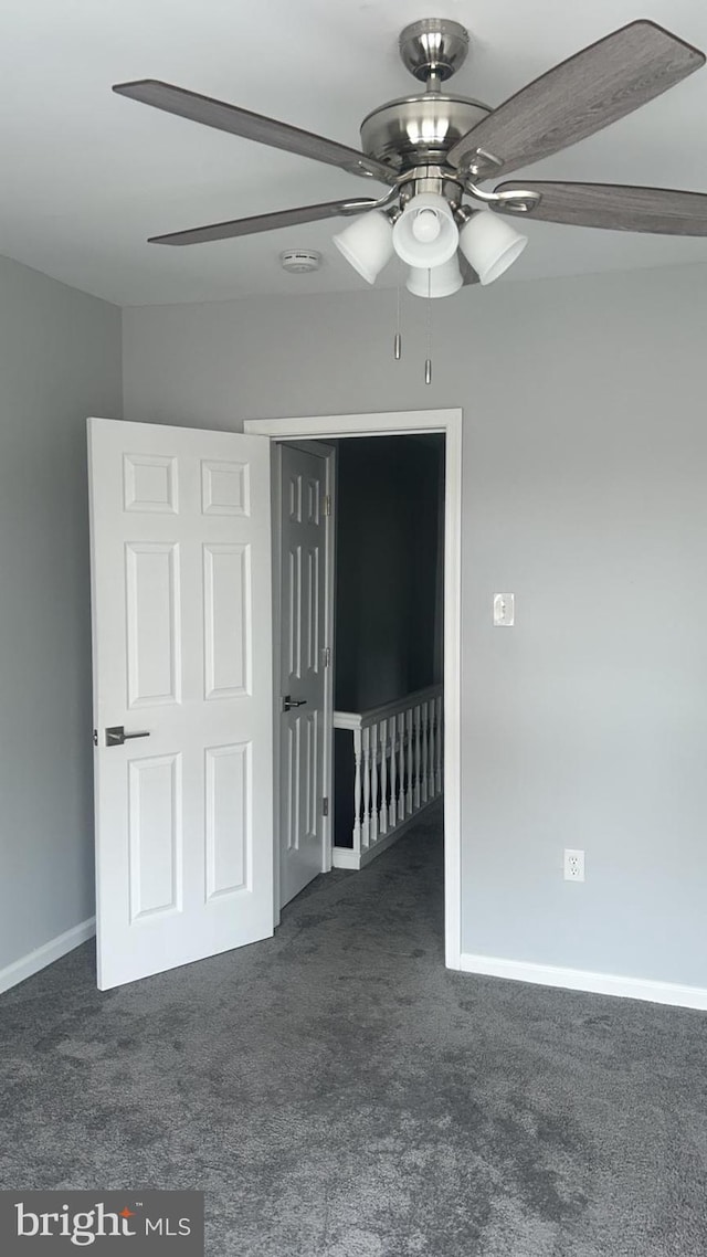 carpeted spare room with ceiling fan