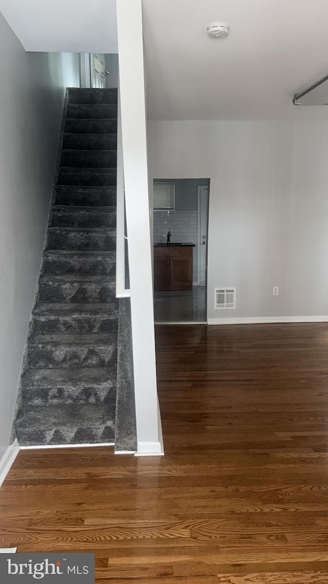 staircase with hardwood / wood-style flooring