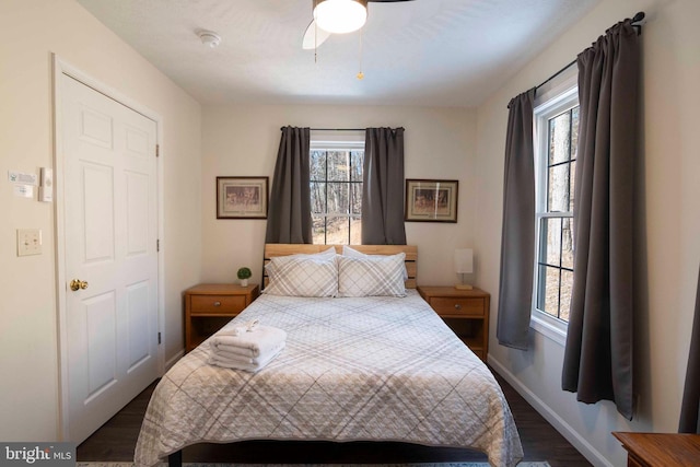 bedroom featuring dark wood finished floors, baseboards, and ceiling fan