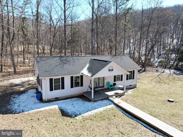 exterior space with a shingled roof, crawl space, and a lawn