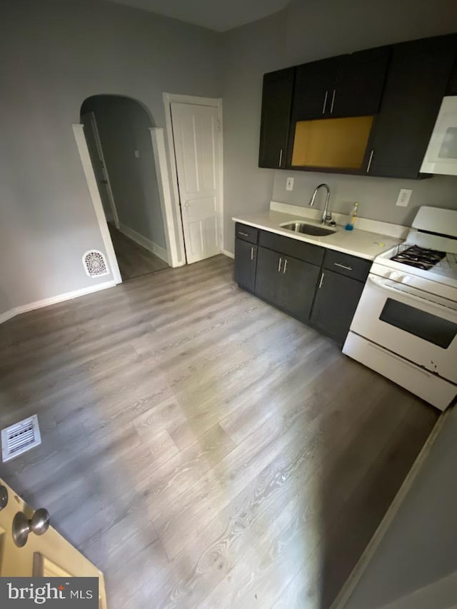 kitchen featuring white appliances, sink, and light hardwood / wood-style flooring