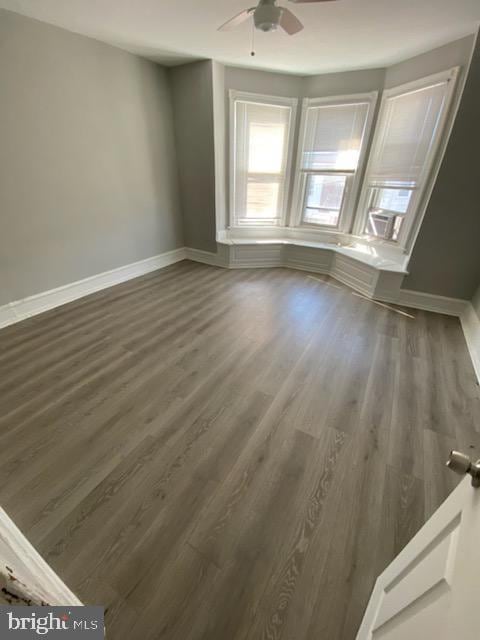 empty room with dark hardwood / wood-style floors and ceiling fan