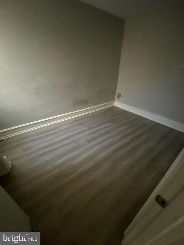 empty room with dark hardwood / wood-style flooring