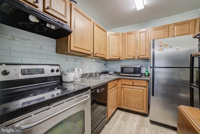 kitchen featuring sink, tasteful backsplash, light wood-type flooring, appliances with stainless steel finishes, and range hood