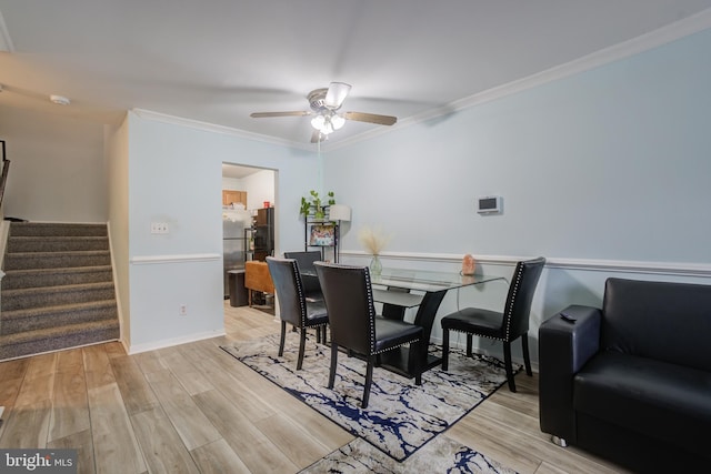 dining space with ornamental molding, ceiling fan, and light wood-type flooring