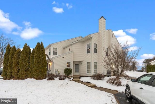 snow covered house featuring cooling unit